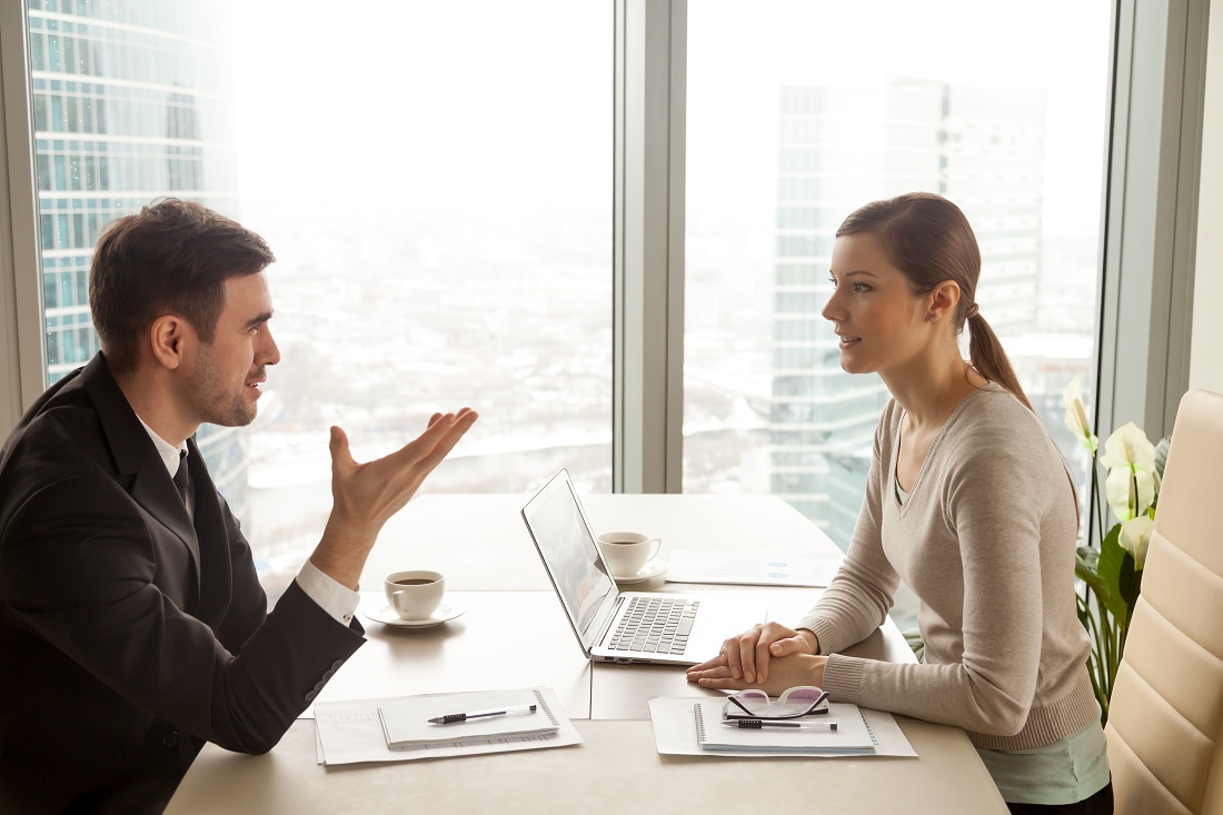 businessman and businesswoman discussing work at office desk businessman and businesswoman discussing work at office desk
