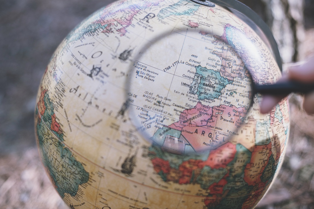 person with magnifying glass looking globe person with magnifying glass looking globe